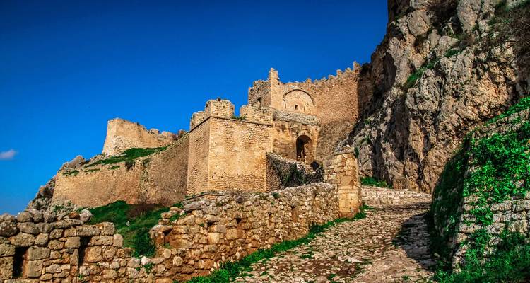 Antigua fortaleza de piedra construida en una ladera rocosa.