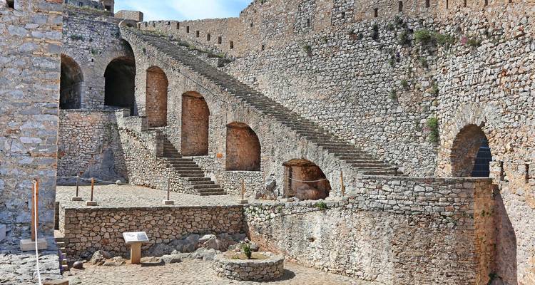 Escaleras interiores dentro de una antigua fortaleza de piedra.