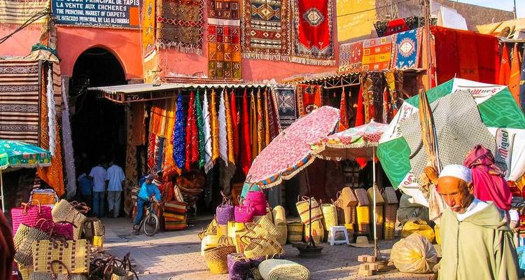 Bunte Marktszene in Marokko mit Menschen beim Stöbern und Händlern, die Waren ausstellen.