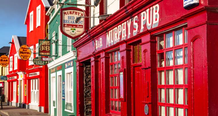 Eine bunte Straße mit roten und blauen Gebäuden in einer kleinen Stadt.