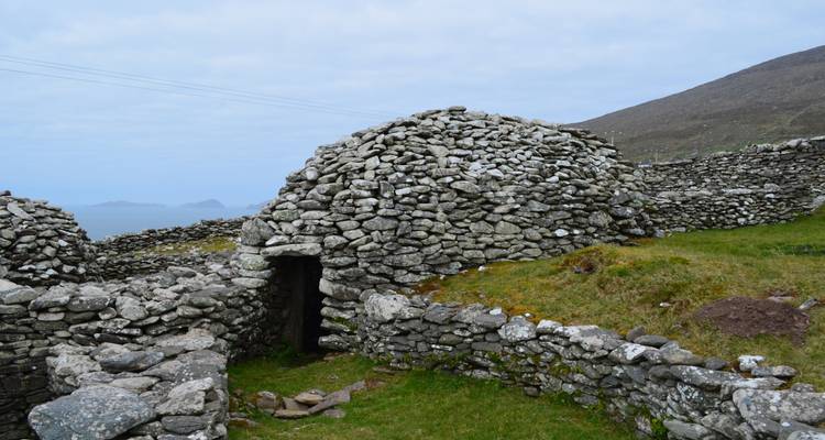 Oude droogmuur bijenkorfhut gebouwd van gestapelde rotsen op een ruige kust heuvelflank