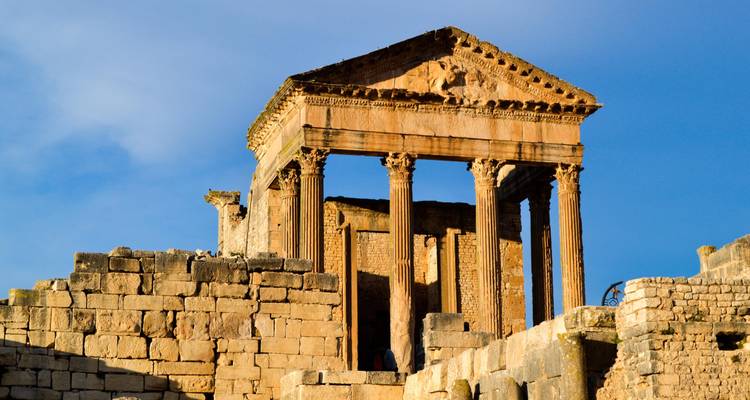 Architecture romaine antique avec colonnes contre ciel bleu.