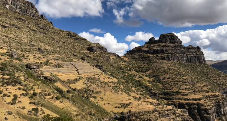 Paisaje montañoso con formaciones rocosas bajo un cielo azul.