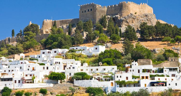 Edificios encalados y un castillo en una colina