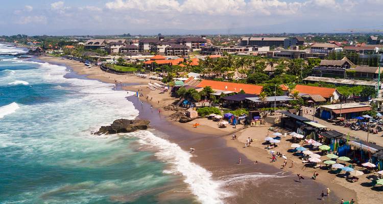Vue aérienne d'une zone côtière avec des vagues qui se brisent sur le rivage.
