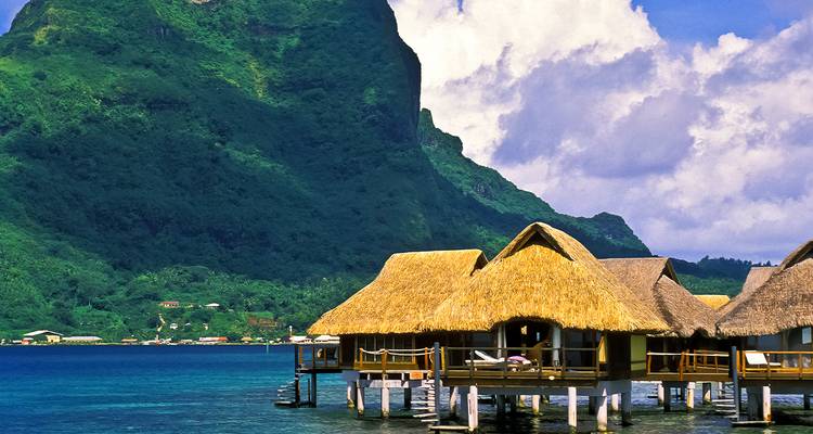Bungalows sobre el agua con un exuberante telón de fondo montañoso