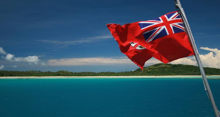 Drapeau Union Jack flottant avec un arrière-plan océanique.