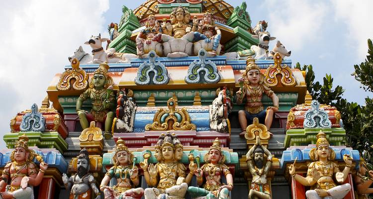 Gros plan de sculptures ornées et colorées sur un gopuram de temple, représentant des divinités.