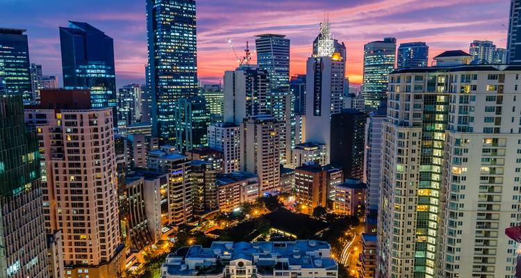 Horizon urbain moderne au coucher du soleil avec des lumières colorées.