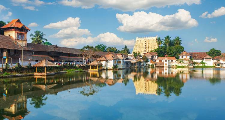 Le temple historique de Padmanabhaswamy se reflète dans un étang serein entouré d'une architecture traditionnelle du Kerala.