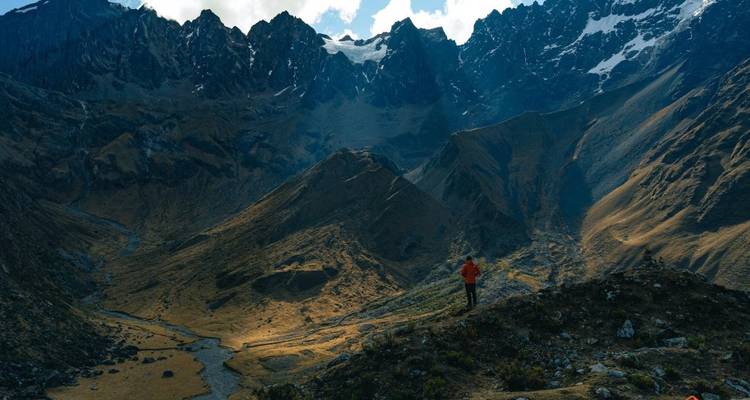 Randonneur solitaire dans un paysage montagneux spectaculaire.