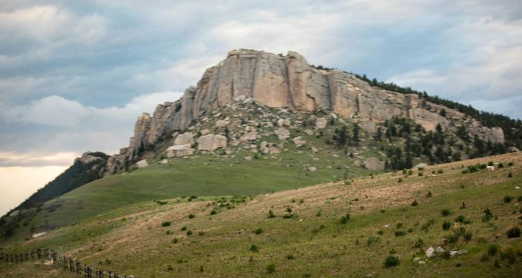 Un paysage montagneux rocheux avec des falaises spectaculaires sous un ciel nuageux.