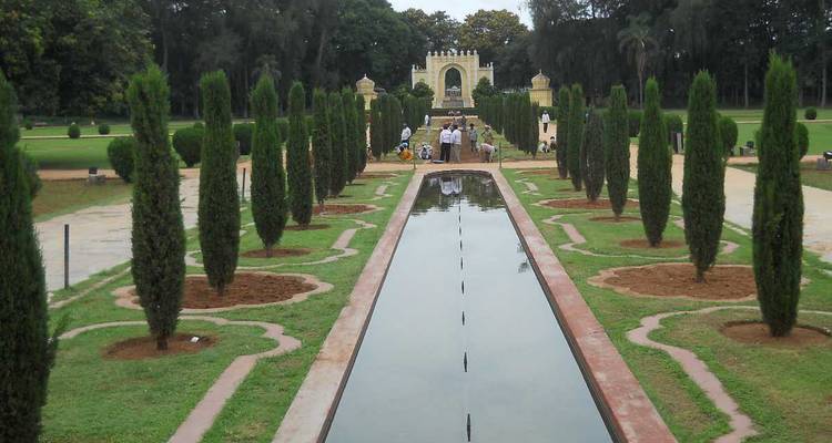 Jardin avec un bassin réfléchissant et des arbres.