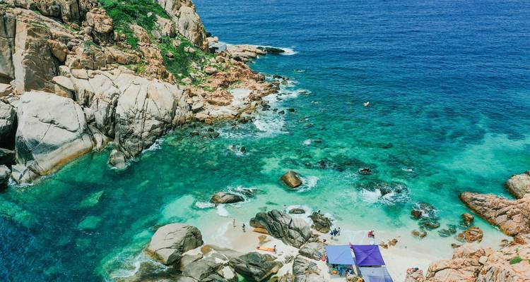 Vue aérienne d'une côte rocheuse et d'eaux turquoise claires.