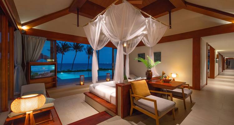 Chambre de villa luxueuse avec vue sur l'océan et mobilier élégant.