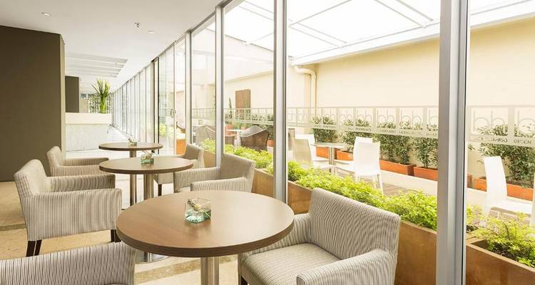 Außenbereich mit modernen Stühlen und Tischen in der Nähe von Pflanzen.