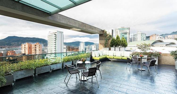 Außenterrasse mit Stadtblick und modernen Möbeln.