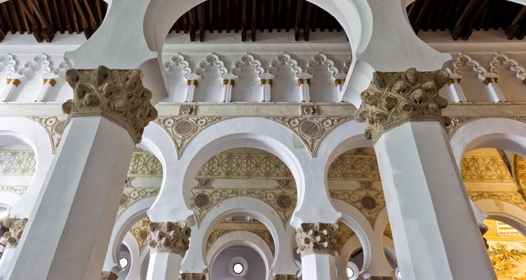 Gepatroneerde witte bogen van een historische synagoge.