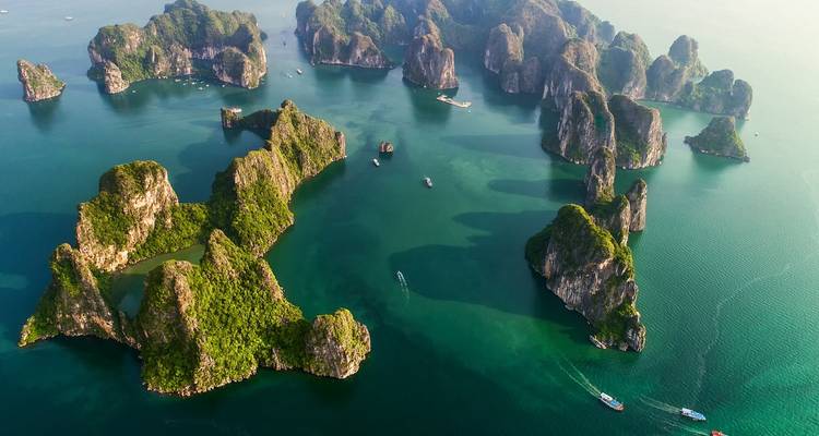 Vista aérea de numerosas islas de piedra caliza exuberantes en aguas esmeralda.