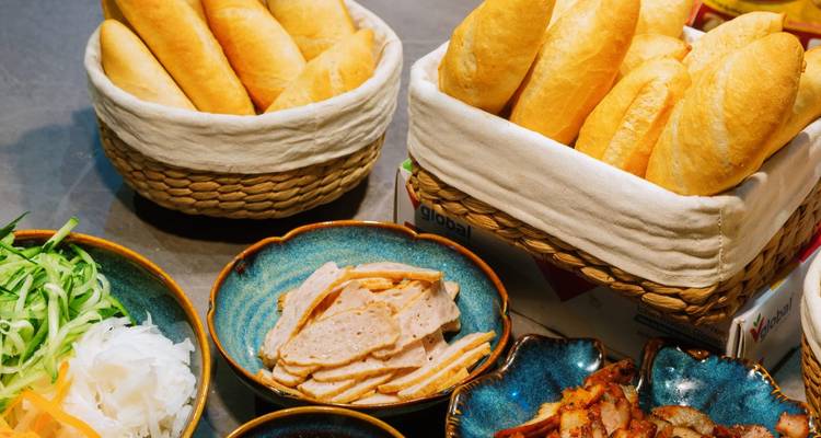 Close-up of various ingredients and baguettes on a table.