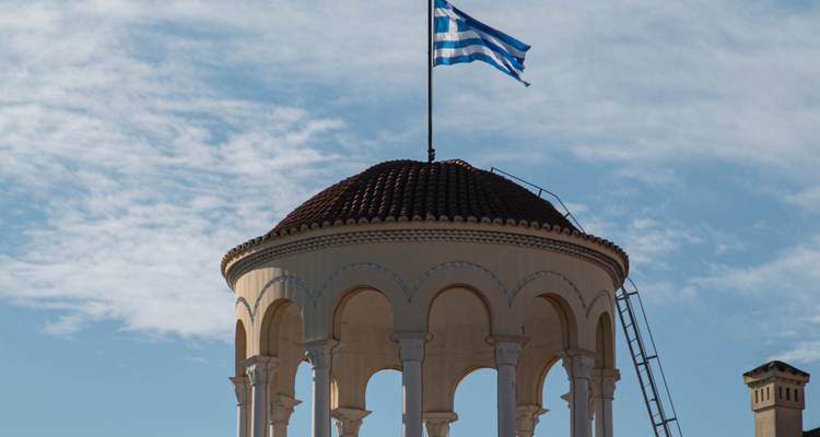 Un bâtiment au sommet en forme de dôme avec un drapeau dessus.