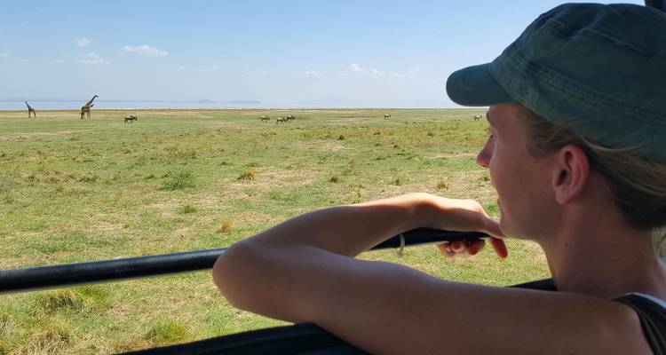 Mujer disfrutando de un safari observando vida silvestre en las llanuras.
