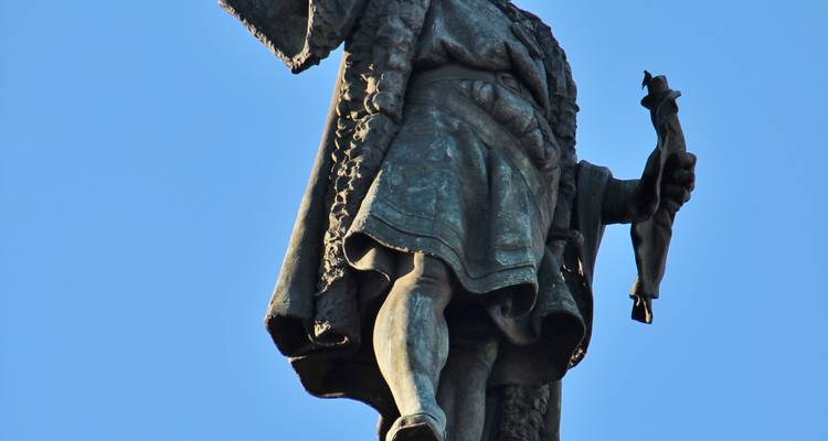 Una estatua de Cristóbal Colón señalando hacia el horizonte.