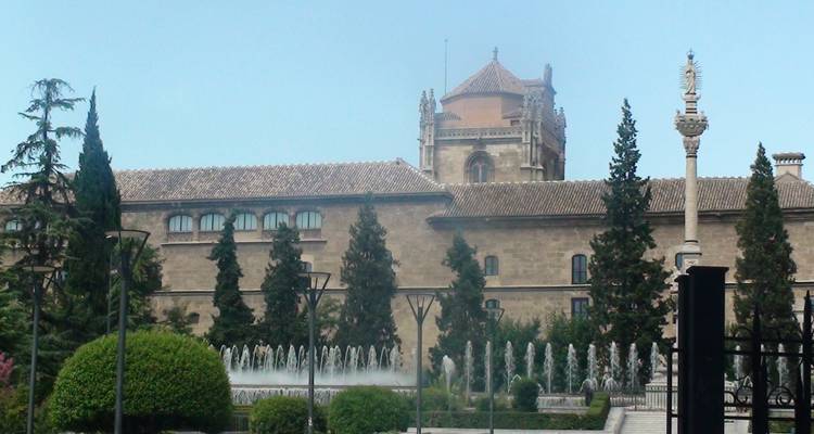 Edificio con fuentes y árboles en primer plano.