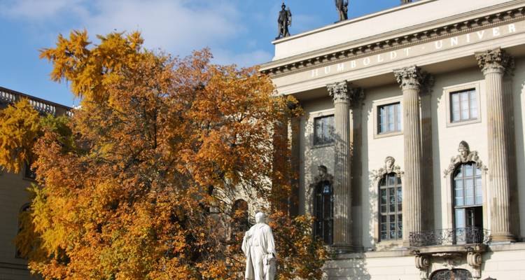 Universidad Humboldt con árboles otoñales y una estatua.