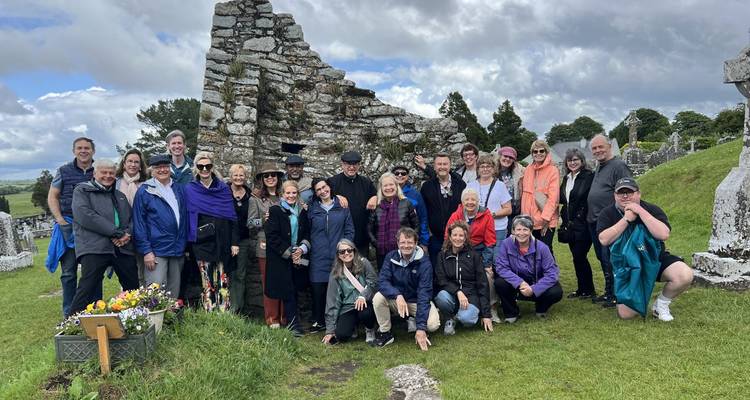 Groupe de personnes posant devant des ruines anciennes.