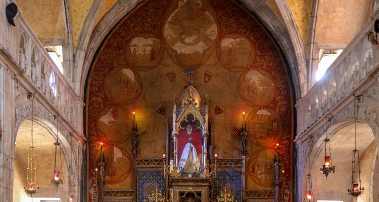 Interior de una iglesia ornamentalmente decorada con luz de velas.