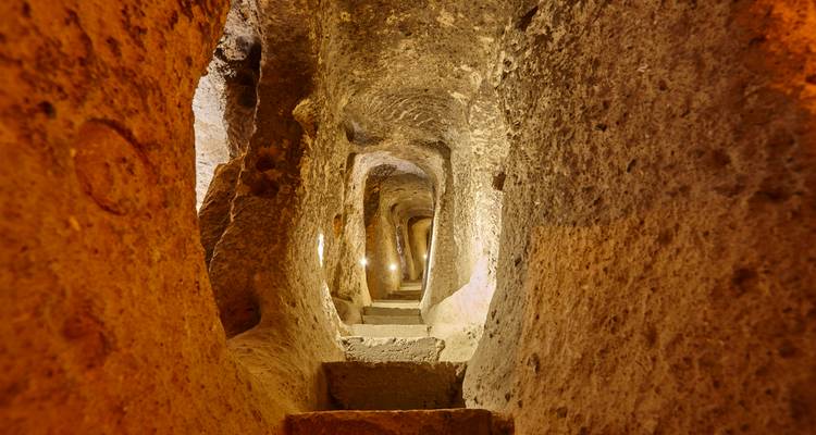 Túnel subterráneo de piedra con iluminación.