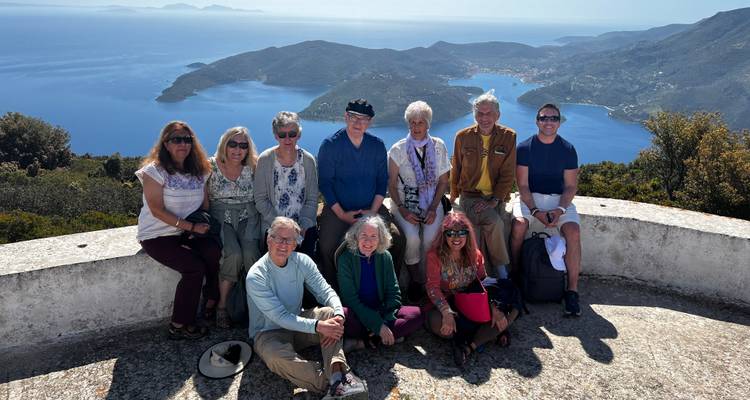 Grupo de personas posando con una vista costera de fondo.