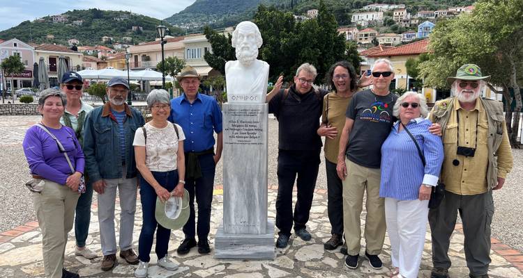 Grupo posando con una estatua en la plaza del pueblo.