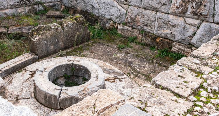 Ruina circular con muros de piedra y un pozo.
