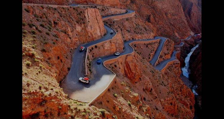 Un camino serpenteante a través de un paisaje de cañón escarpado, visto desde arriba.