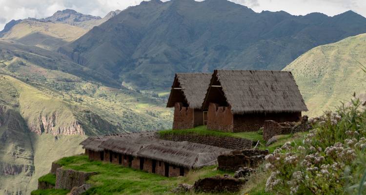 Casas tradicionales con techo de paja con valles verdes y montañas.