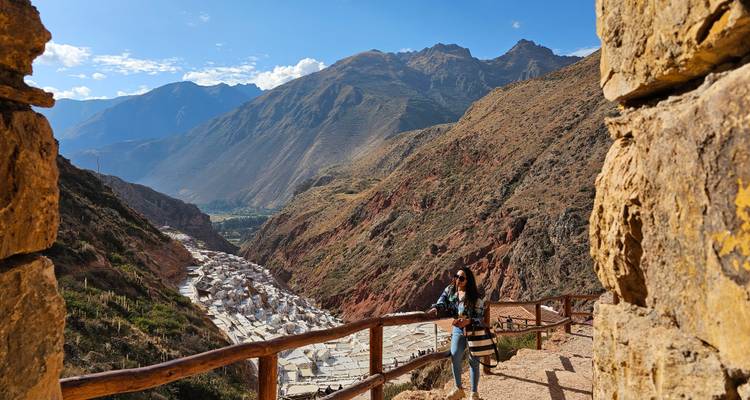 Persona de pie en las salinas de Maras con montañas.