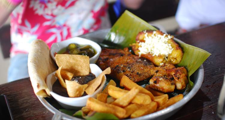 Bord gevuld met een verscheidenheid aan traditionele voedingsmiddelen waaronder vlees, friet en tortilla's.