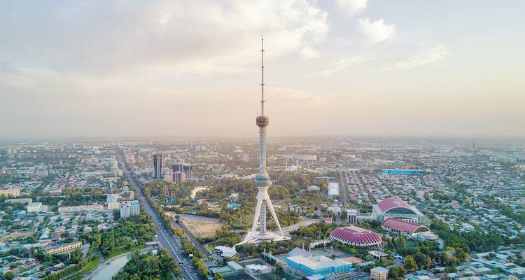 Aerial view of a city with a prominent telecommunications tower.