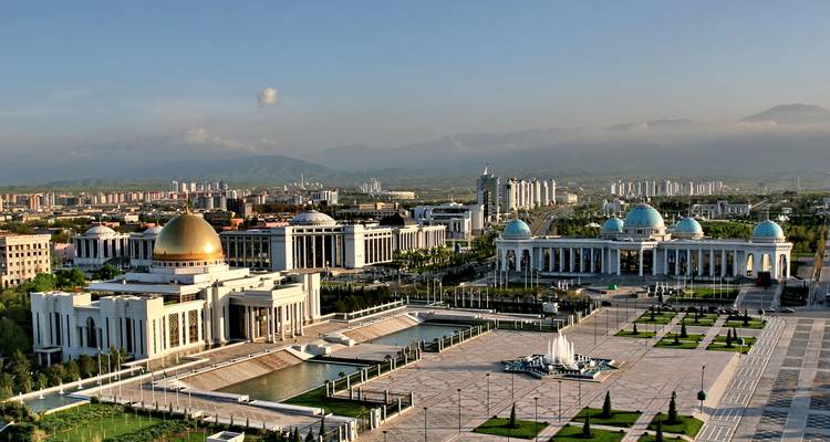 Cityscape with grand buildings, fountains, and landscape.