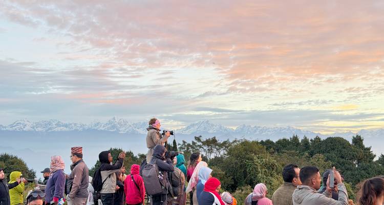 Gruppe von Menschen, die den Sonnenaufgang über dem Himalaya beobachten.