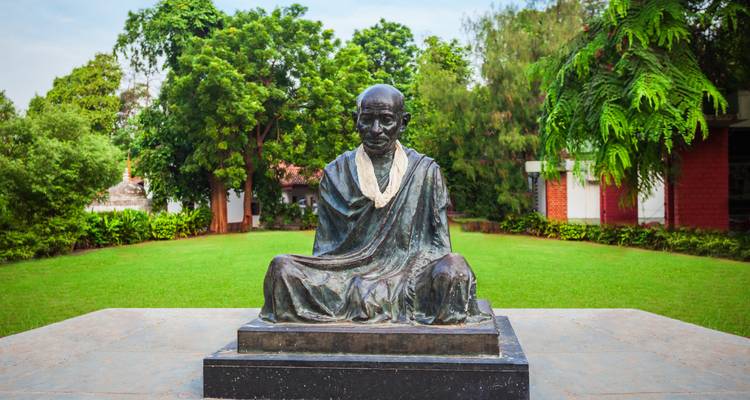 Estatua de Mahatma Gandhi en un entorno de jardín.