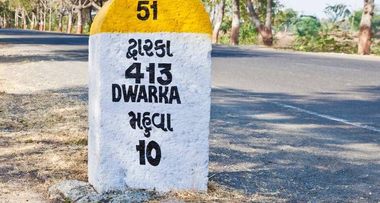 Señal de tráfico que indica la distancia a Dwarka y Mechi.