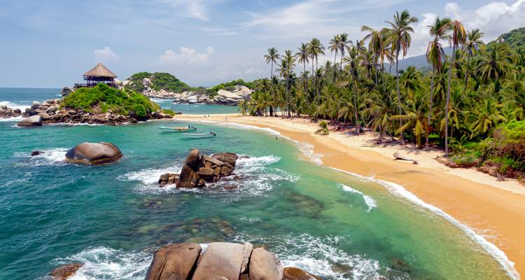 Plage pittoresque avec des eaux claires et une végétation tropicale.