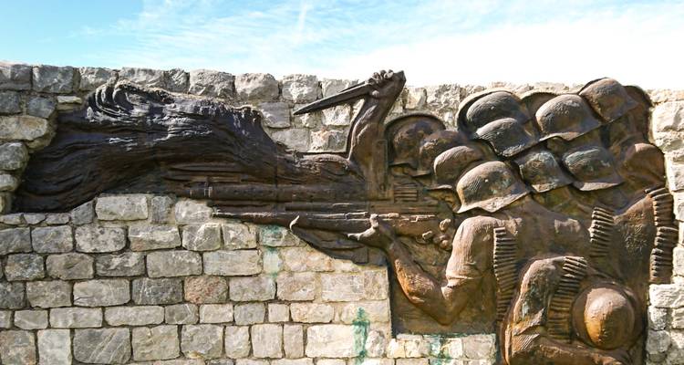 Relieve de piedra que representa soldados y varios símbolos.