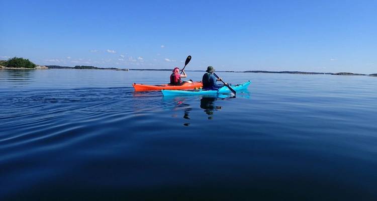 Personas navegando en kayak en aguas marinas tranquilas.