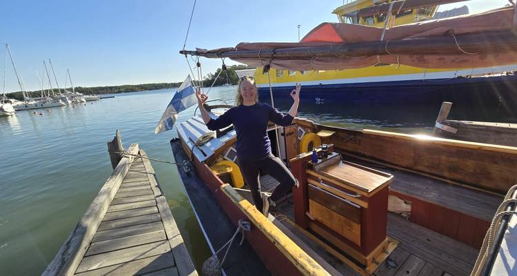 Mujer sonriente en un velero en el puerto.