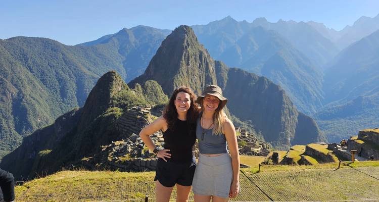 Dos personas posando con las ruinas de Machu Picchu al fondo.