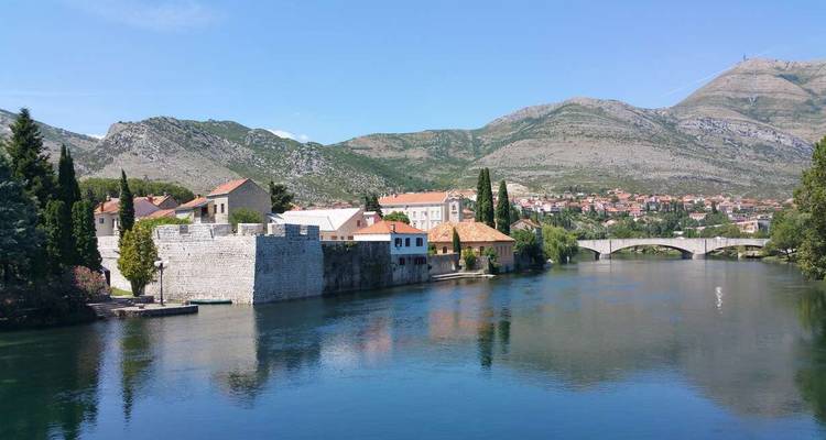 Río y edificios históricos en un pueblo pintoresco.